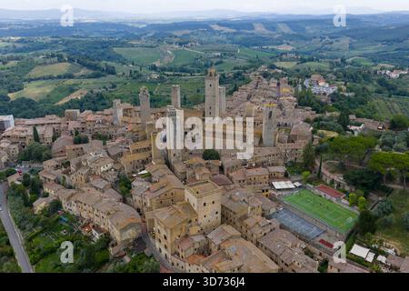 Vue aérienne des tours de pierre médiévales de San Gimignano et des remparts de la ville s'élevant au-dessus de la campagne toscane, ville marchande historique sur la via Francigena. Banque D'Images