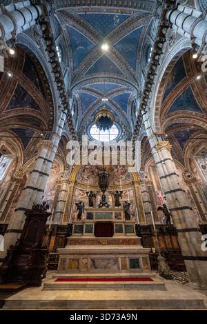 Sienne, Italie - 19 juillet 2025 : L'intérieur de la cathédrale de Sienne présente des arches gothiques, des rayures de marbre noir et blanc et des fresques complexes. Banque D'Images