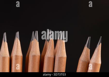 un groupe de crayons en bois sur fond noir, des crayons empilés en bois et une mine en graphite Banque D'Images