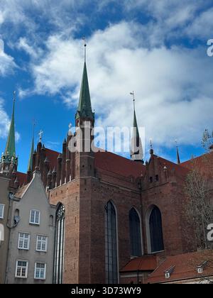 L'église de Marie surplombe les bâtiments de Gdańsk, présentant une architecture gothique en briques Banque D'Images