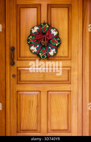Couronne de Noël festive Hung sur porte en bois chaude pour photo de décor de vacances à l'entrée Banque D'Images