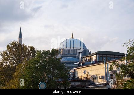 Dôme de mosquée doré visible à travers la vieille rue du quartier d'Istanbul avec des câbles et des bâtiments - paysage urbain montrant l'architecture ottomane historique Banque D'Images