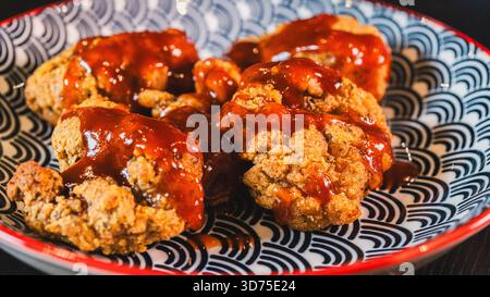 Poulet frit coréen croustillant glacé avec une sauce Chili rouge douce. Collant, épicé-sucré, et parfaitement cuit. Idéal pour les hors-d'œuvre ou les plats principaux. Banque D'Images