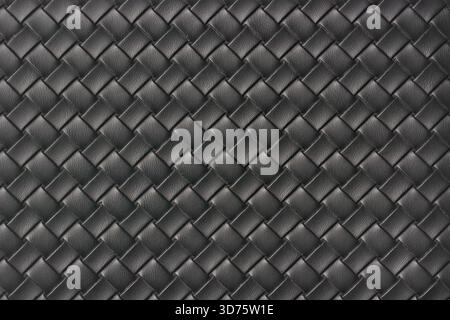 gros plan de texture de cuir tissé noir, motif uniforme de tissage de panier diagonal en plein cadre, fond ou toile de fond en matière synthétique de luxe Banque D'Images