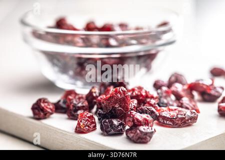 Savoureuses canneberges séchées sur une table blanche. Banque D'Images
