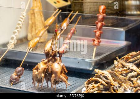 Cailles et brochettes de viandes présentées sous la rubrique Asian Street Food Banque D'Images