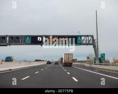 Frioul, Italie 21 novembre 2025 conduite sur l'autoroute A4 italienne sous un panneau électronique qui montre des informations sur les règlements des pneus d'hiver et Banque D'Images