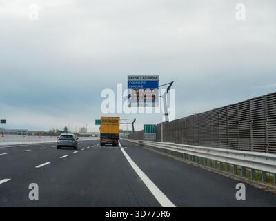 Frioul, Italie 21 novembre 2025 conduite sur une autoroute italienne, approchant d'une sortie pour Latisana et d'autres destinations Frioul, avec un camion et une voiture A. Banque D'Images