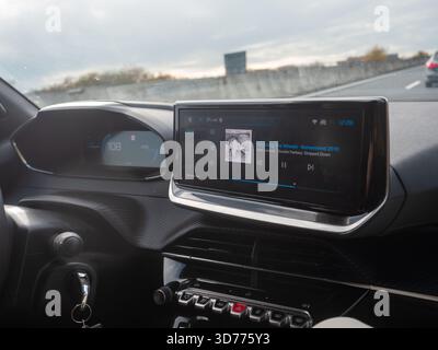 Frioul, Italie 21 novembre 2025 Tableau de bord de voiture moderne affichant la vitesse et l'écran central. Concept de voyage sur route, de technologie et de divertissement tout en Banque D'Images