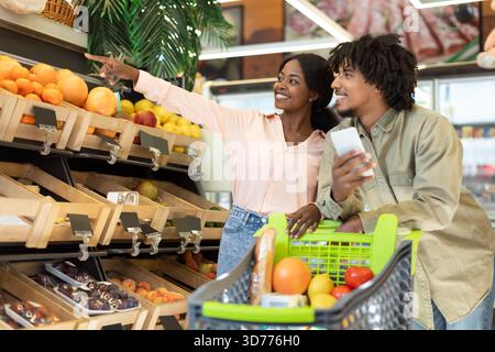 Jeune couple aime faire du shopping pour des fruits et légumes frais ensemble dans une épicerie pendant l'après-midi Banque D'Images