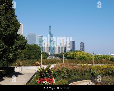Chicago, il - 16 septembre 2025 : un sentier ensoleillé dans les jardins de Grant Park menant à l'éminent Regis Chicago et aux gratte-ciel environnants. Banque D'Images