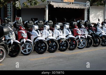 Rangée de scooters de location garés dans la rue Banque D'Images