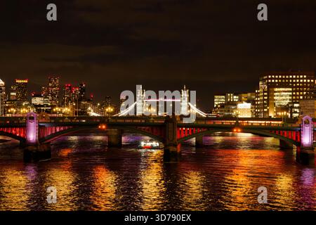 Vue nocturne éclairée le long de la Tamise avec Southwark et Tower Bridge traversant la rivière, Londres, Angleterre. Banque D'Images