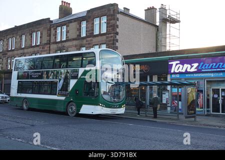 Bus Lothian à impériale qui prend des passagers à un arrêt de bus de banlieue d'Édimbourg par un matin froid. Édimbourg, Écosse Banque D'Images