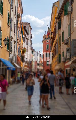 Une rue animée remplie de gens dans la charmante ville de Rovinj, en Croatie, par un après-midi ensoleillé, présentant des bâtiments dynamiques et des magasins locaux Banque D'Images