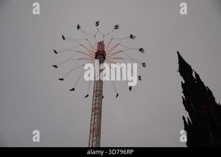 Tour de foire à balancement élevé tournant au-dessus d'Édimbourg avec le Scott Monument silhouetté à côté d'it.Edinburgh, Écosse Banque D'Images