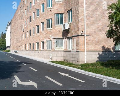 Unité AC attachée à un bâtiment en briques avec fenêtres à cadre blanc Banque D'Images