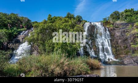 Vue aérienne des cascades plonger dans les falaises rocheuses au milieu d'une végétation verdoyante, chutes d'eau d'Aruu, région du Nord, Ouganda. Banque D'Images