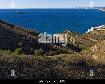 Vue sur la mer Méditerranée depuis une colline à Benidorm, Espagne où une ancienne route étroite monte jusqu'au sommet Banque D'Images