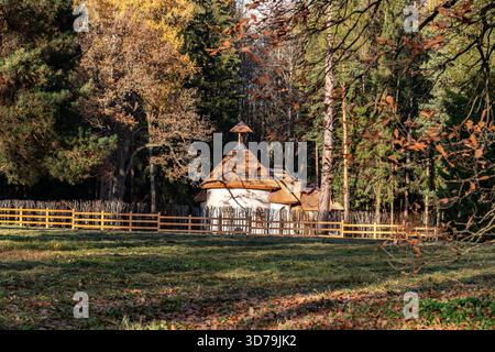 Old Chalet est une petite maison blanche avec un toit de chaume et une clôture en bois dans le parc municipal de Pavlovsk un jour d'automne ensoleillé. Banque D'Images