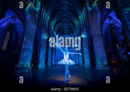 Londres, Royaume-Uni. 24 novembre 2025. La ballerine Sophie Elizabeth scintille dans le « The Angels are coming ! » Spectacle de lumière de Luxmuralis à la cathédrale de Southwark. La collaboration entre la sculpture et l’artiste Peter Walker et le compositeur David Harper apporte des projections impressionnantes de lumière et de son festifs angéliques à l’intérieur de la cathédrale du 24-26 au 29 novembre. Crédit : Guy Corbishley/Alamy Live News Banque D'Images