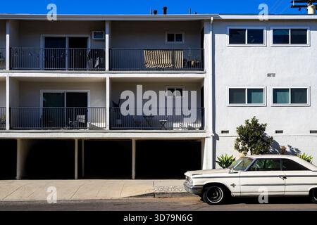 Voiture ancienne 1963 Ford Galaxie 500 garée dans un immeuble d'appartements de style dingbat à Los Angeles, avec des places de parking « soft story », architecture rétro Banque D'Images