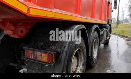 Gros plan de la roue arrière d'un camion de marchandises rouge. Phares et roues de la voiture. Le concept de transport de marchandises. Banque D'Images
