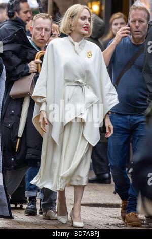 Angelina jolie filme des scènes de la prochaine série Anxious People sur place à l'île des chiens, Londres. Jolie, vêtue d'une tenue blanche et de cheveux blonds, a été vue sur le plateau avec l'équipe de production pendant le tournage en plein air. Banque D'Images