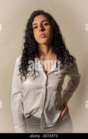 Jeune femme confiante posant avec une expression sérieuse en studio pour un portrait Banque D'Images