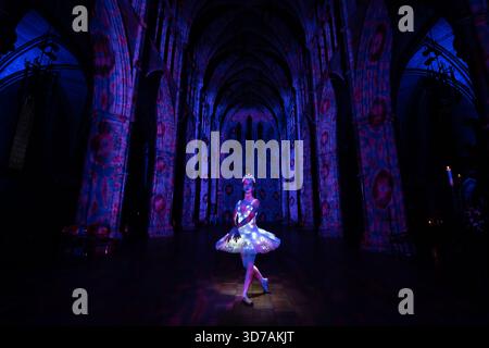 Londres, Royaume-Uni. 24 novembre 2025. La ballerine Sophie Elizabeth scintille dans le « The Angels are coming ! » Spectacle de lumière de Luxmuralis à la cathédrale de Southwark. La collaboration entre la sculpture et l’artiste Peter Walker et le compositeur David Harper apporte des projections impressionnantes de lumière et de son festifs angéliques à l’intérieur de la cathédrale du 24-26 au 29 novembre. Crédit : Guy Corbishley/Alamy Live New Banque D'Images