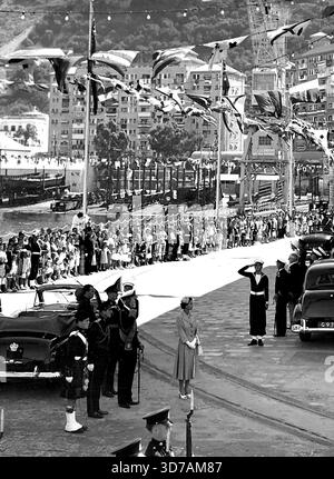 La reine arrive à Gibraltar -- la reine Elizabeth est toujours en mesure de reconnaître le salut alors qu'elle quitte le chantier naval après les cérémonies qui l'ont accueilli à Gibraltar aujourd'hui, le 10 mai. Le Royal Party avait navigué sur le Liner Britannia pour une visite de 27 heures à la forteresse, le dernier port d'appel de la visite du Commonwealth. Derrière la Reine, se trouve le duc d'Édimbourg. 20 mai 1954. (Photo par photo de presse associée). Banque D'Images
