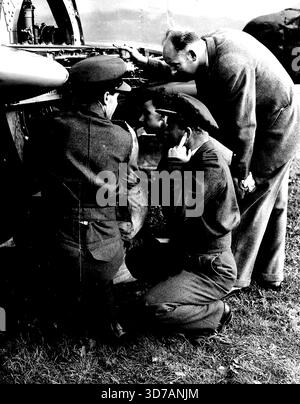 Jets se préparent à la soumission record -- le capitaine de groupe E.M. Donaldson (en bas à droite) met les doigts de ses oreilles alors qu'il vérifie la note de l'une des unités à réaction installées aujourd'hui (mardi) dans le Meteor qu'il utilisera dans sa tentative de record du monde de vitesse. Le vol à grande vitesse R.A.F., dirigé par le capitaine du groupe E.M. Donaldson, attend des conditions météorologiques favorables pour son attaque contre le record du monde de vitesse de 606-25 m.p.h. les mécaniciens ont travaillé dur à l'aérodrome de Tangmere, près de Chichester, Sussex, installant les moteurs à turbine à gaz Rolls-Royce spécialement préparés dans les météores Gloster qui seront utilisés pour t Banque D'Images