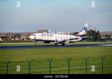 Bruxelles, Belgique - 22 novembre 2025 : SunExpress Boeing 737 atterrisse à Brussels Zaventem avec piste et premier plan vert dans une lumière chaude tardive. Banque D'Images