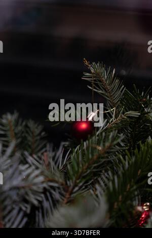 Intérieur de vacances confortable avec un canapé en velours vert foncé, des murs de briques, des arbres de Noël ornés de lumières et des lumières chaudes pour créer une fête Banque D'Images