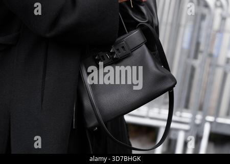Paris, France - 4 octobre 2025 : femme porte un sac à bandoulière noir Hermes Medor, détails de tenue élégants et style urbain Banque D'Images