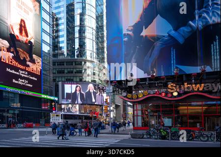 Scène de Times Square occupée dans la ville de New York avec des panneaux d'affichage illuminés, de hauts gratte-ciel en verre, des magasins de détail et une activité urbaine dynamique. Banque D'Images