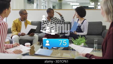 Discutant moutarde-veste homme sur canapé dans le bureau tenant dossier bleu à la table en verre, icône de l'utilisateur 75 Banque D'Images