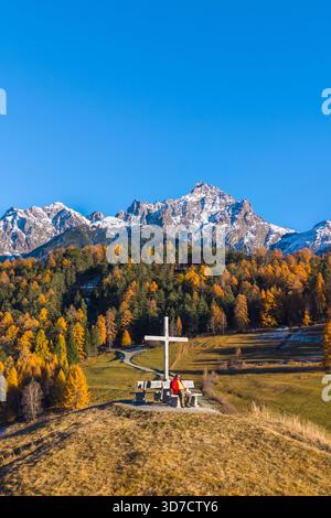 Vue aérienne d'une personne admirant les montagnes entourant Tarasp en automne. Basse Engadine, canton des Grisons, Suisse, Europe. Banque D'Images