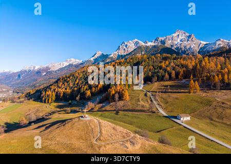 Vue aérienne d'une personne admirant les montagnes entourant Tarasp en automne. Basse Engadine, canton des Grisons, Suisse, Europe. Banque D'Images