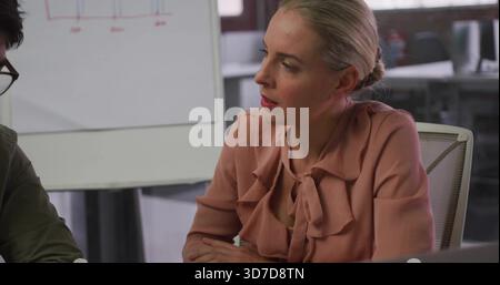 Femme adulte penchée dans la blouse volante pêche avec arc s'engageant dans la réunion de bureau, tableau de conférence Banque D'Images