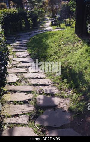 Ce grand bâtiment résidentiel contemporain allie un toit incurvé asiatique à des balcons en verre et à une végétation luxuriante. Banque D'Images