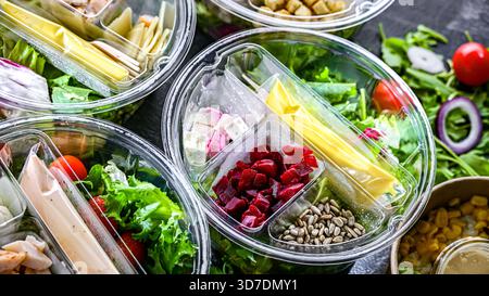 Boîtes rondes en plastique avec salades de légumes préemballées. Plats cuisinés Banque D'Images