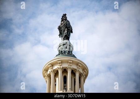 WASHINGTON DC — la Statue de la liberté en bronze est vue au sommet du dôme du Capitole des États-Unis. Conçue par le sculpteur américain Thomas Crawford, la statue colossale a été placée en 1863. Il représente une figure féminine drapée portant un casque orné d'une tête d'aigle et tenant une épée gainée et un bouclier. La statue mesure environ 5,9 mètres (19 pieds 6 pouces) de haut et pèse environ 6 800 kg (15 000 livres), servant de symbole de la liberté à Washington DC. Banque D'Images