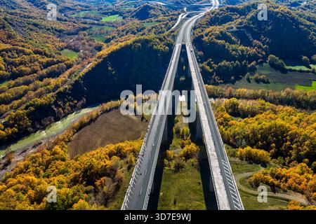 Vue aérienne de l'autoroute Egnatia surélevée au-dessus de la forêt d'automne dans le nord de la Grèce, montrant les infrastructures se mélangeant avec la nature. Banque D'Images