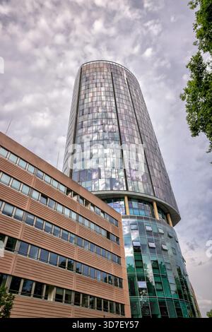 Köln Tour Triangle vue de Deutz avec des voies ferrées, des voies d'autoroute et de la verdure sous un ciel nuageux à Cologne, en Allemagne. Banque D'Images