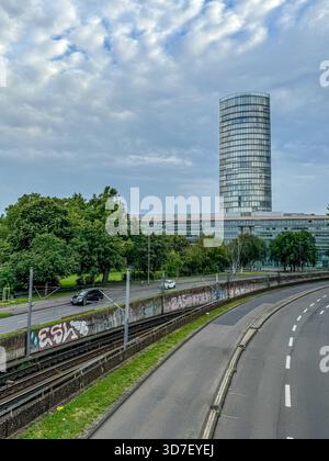 Köln Tour Triangle vue de Deutz avec des voies ferrées, des voies d'autoroute et de la verdure sous un ciel nuageux à Cologne, en Allemagne. Banque D'Images