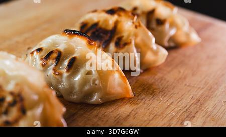 Beaux gyozas dorés parfaitement disposés sur une assiette. Fond croustillant, garniture juteuse, idéal pour les hors-d'œuvre ou les repas d'inspiration asiatique. Traditionnel et del Banque D'Images
