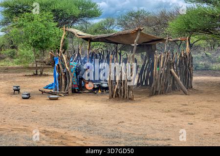 femme africaine cuisinant sur un feu ouvert et lavant la vaisselle traditionnelle, abri. Commun dans diverses communautés rurales africaines, Botswana, vie quotidienne Banque D'Images