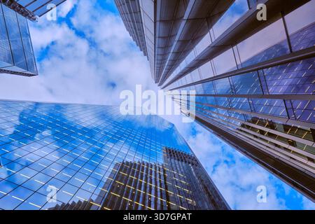 Vue grand angle des gratte-ciels de la City de Londres contre un ciel bleu avec un nuage léger. Banque D'Images