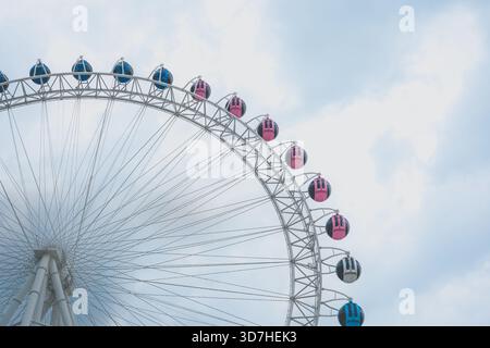 Vue majestueuse d'une grande roue avec des gondoles colorées bleu et rose contre le Banque D'Images